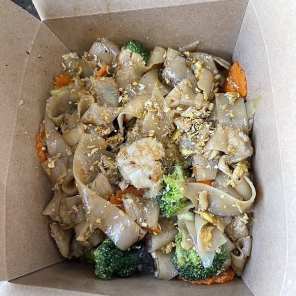 Easy Thai Bend's Pad See Ew with wide noodles, broccoli, carrots, and shrimp in a takeout box.